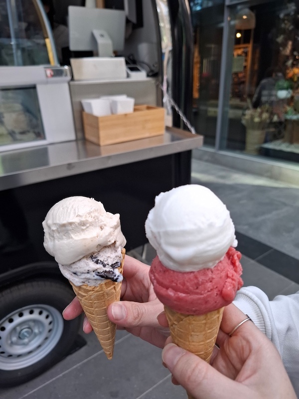 Vier Kugeln Eis in zwei Waffeln vorm Eiswagen