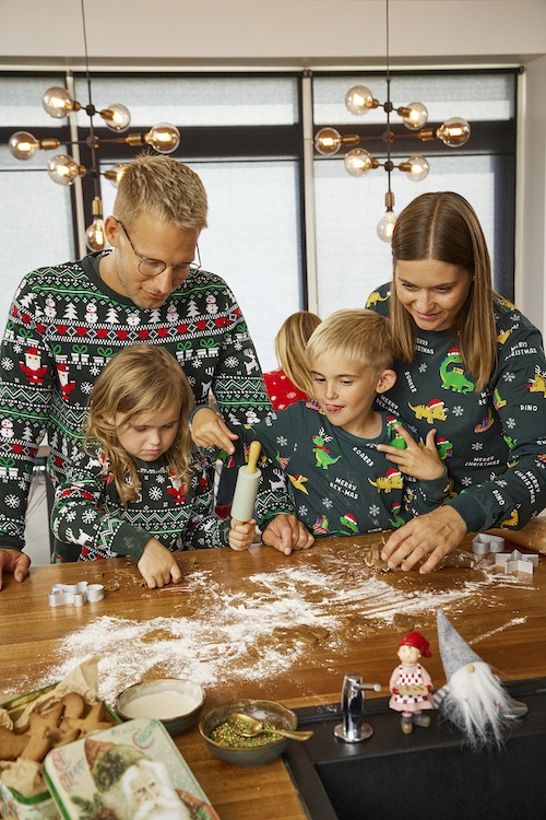Familie mit Weihnachtspullovern beim backen